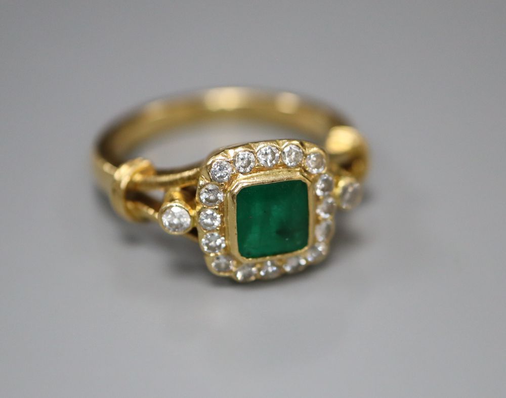 A modern 18ct gold, emerald and diamond cluster ring, size N, gross 6.6 grams.